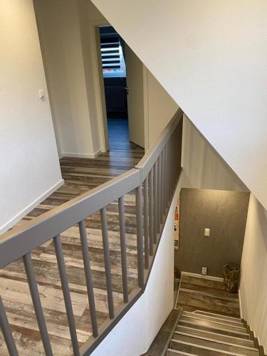 a staircase in a house with a cat sitting on the floor at Ermmes Ferienwohnungen in Sinsheim