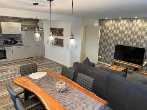 a living room with a couch and a dining room table at Ermmes Ferienwohnungen in Sinsheim