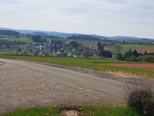 an empty road with a village in the distance at Haus Eifelblick in Gönnersdorf