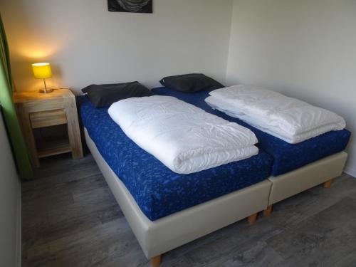 2 almohadas blancas en una cama en una habitación en Kustverhuur, Landgoed de Lente, en Breskens