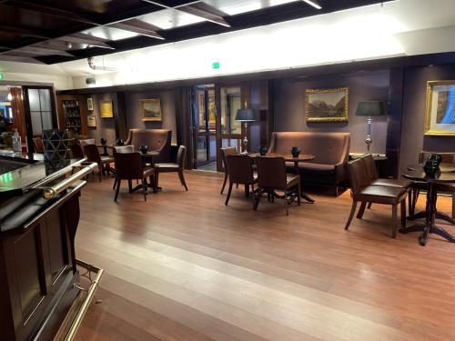 a restaurant with chairs and tables and a bar at Klækken Hotel in Hønefoss