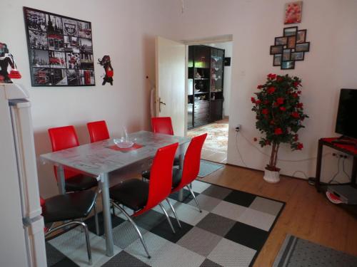 a dining room with a table and red chairs at 2 L in Jablanac