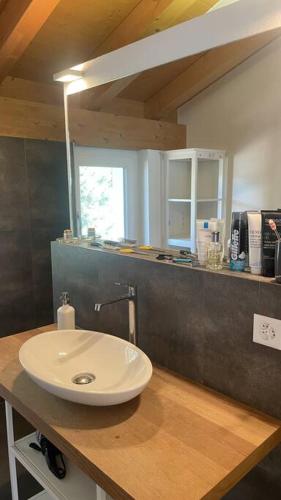 a bathroom with a white sink on a wooden counter at Terrace Vista Interlaken in Interlaken