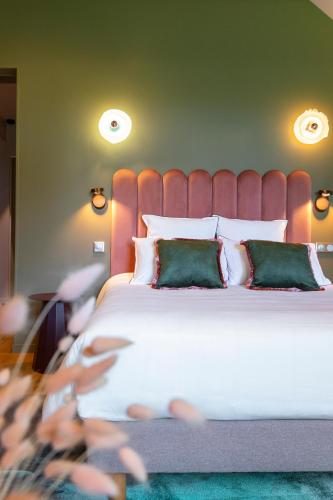 a bedroom with a large white bed with green pillows at Auberge Pom'Poire in Azay-le-Rideau