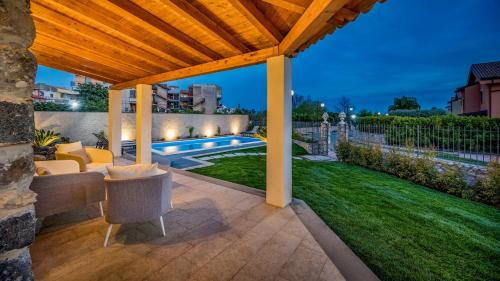a backyard with a pergola and a swimming pool at VILLA GALLUS 6, Emma Villas in Taormina