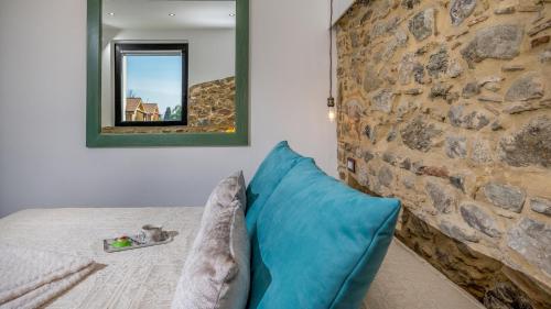 a room with a blue pillow and a stone wall at VILLA GALLUS 6, Emma Villas in Taormina