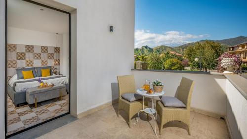 a bedroom with a bed and a table on a balcony at VILLA GALLUS 6, Emma Villas in Taormina