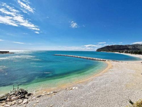 a beach with blue water and a rocky shore at Casa Vacanze Rinaldi in Mattinata