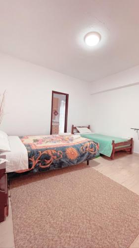 a bedroom with two beds and a rug at Villa Maria (3) in Paleokastritsa