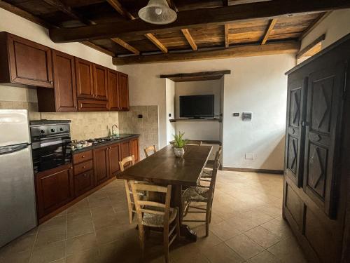 a kitchen with a table with chairs and a refrigerator at Il Rifugio del Brigante in Sante Marie