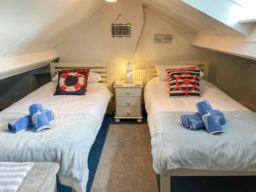 two twin beds in a attic bedroom with at Billy Napps Cottage in Filey