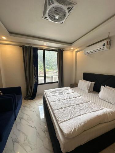 a bedroom with a large bed and a window at Hotel La Orilla Muzaffarabad in Muzaffarabad
