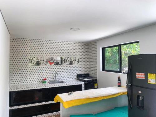 a small kitchen with a sink and a refrigerator at CASA BLANCA EN LA VEGA in La Vega