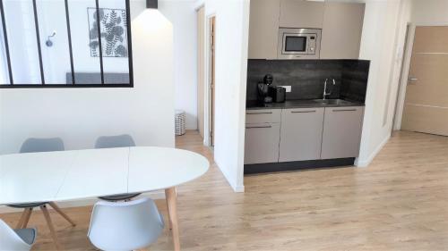 une cuisine blanche avec une table et des chaises blanches dans l'établissement Hypercentre lamartine 308, à Nice
