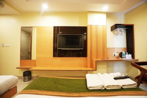 a hotel room with a tv and a bed with towels at Hotel Aman Imperial Near New Delhi Railway Station in New Delhi