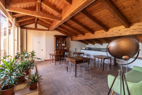 una sala de estar con techos de madera, mesas y sillas en Casa Isolani - Santo Stefano, en Bolonia