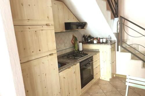 una cucina con armadi in legno e piano cottura di Casa Teria a Villasimius