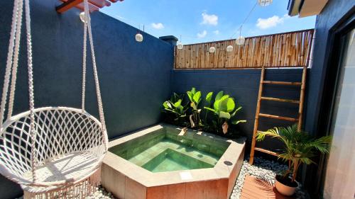 a hammock and a hot tub in a backyard at The Farm Shack Casitas in Amadeo