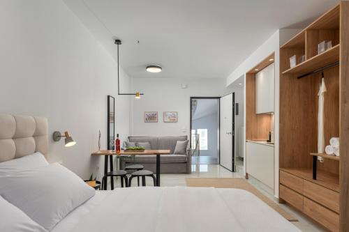 a bedroom with a bed and a table and a kitchen at ΙΩΚΑ Suites / the Urbitality Project in Thessaloniki