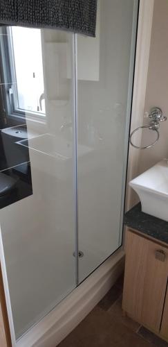 a glass shower in a bathroom with a sink at The Sherbourne in Selsey