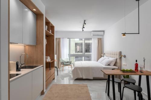 a kitchen and a bedroom with a bed and a table at ΙΩΚΑ Suites / the Urbitality Project in Thessaloniki