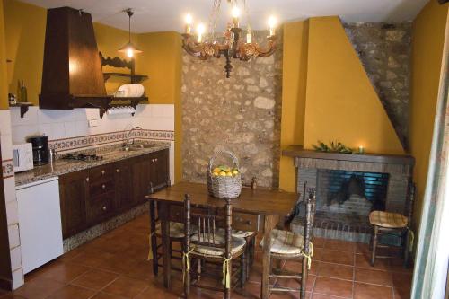 a kitchen with a table and a fireplace at Casa Rural Las Martas in Acebo