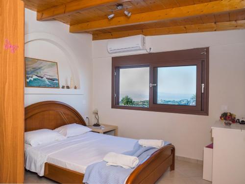 a bedroom with a bed and two windows at Two little houses with panorama view in Kýthira