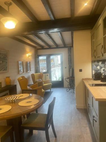 une cuisine et un salon avec une table et des chaises dans l'établissement Nid douillet, à Pont-Audemer