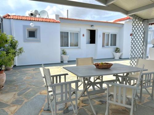 Une table et des chaises en bois sont disponibles sur la terrasse. dans l'établissement Afiartis Avli House, à Karpathos