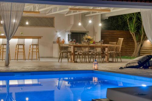 a patio with a table and chairs and a pool at Aigli Villa in Zakynthos Town