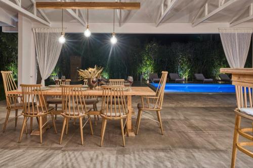 a dining room with a wooden table and chairs at Aigli Villa in Zakynthos Town