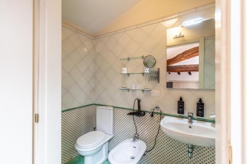 a bathroom with a toilet and a sink at Casa Isolani Charms Rooms Santo Stefano in Bologna
