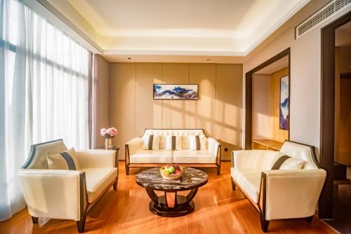 a living room with two white couches and a table at Guangzhou Southern Airlines Pearl Airport Hotel- Free shuttle bus to airport in Guangzhou