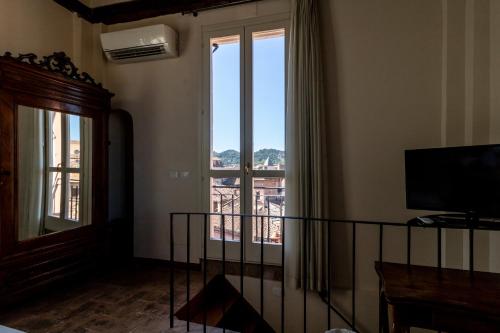 a room with a large window with a view at Casa Isolani Charms Rooms Santo Stefano in Bologna