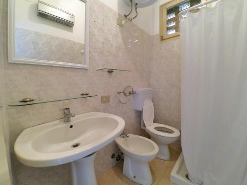 y baño con lavabo, aseo y espejo. en Lido, en Lido delle Nazioni