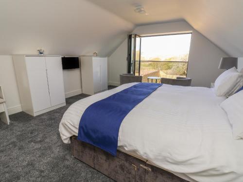 a bedroom with a large bed with a large window at Kerry Cottage in Holywell