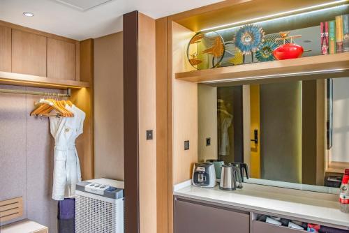 a kitchen with a sink and a mirror at Guangzhou Southern Airlines Pearl Airport Hotel- Free shuttle bus to airport in Guangzhou