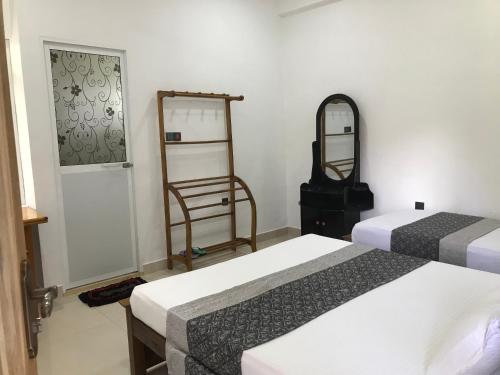 ジャフナにあるGreen star villaのベッド2台と鏡が備わるホテルルームです。