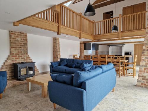 a living room with a blue couch and a fireplace at The Hayloft in Lincolnshire