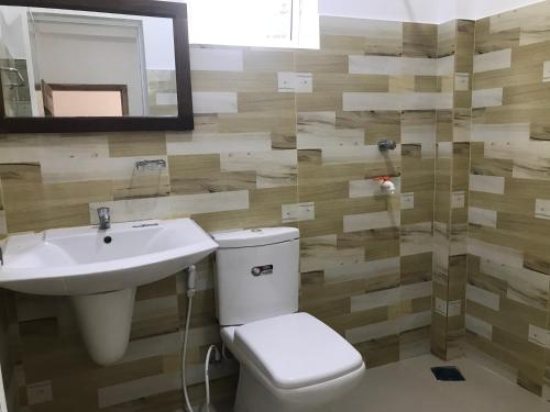 a bathroom with a toilet and a sink and a mirror at Green star villa in Jaffna