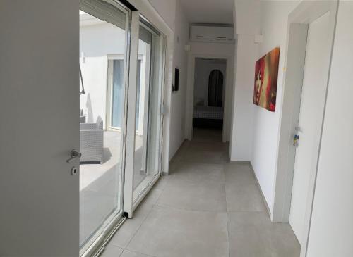 a hallway with a glass door leading to a room at Soffio del Salento in Matino
