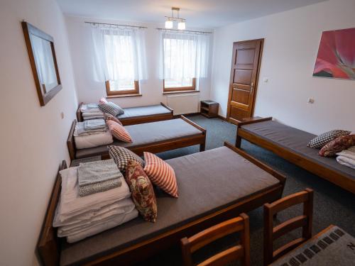 Zimmer mit 4 Betten und Kissen darauf in der Unterkunft Zajazd w Biskupinie in Biskupin