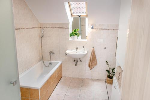 y baño con bañera y lavamanos. en Vinařský apartmán Špalek, en Nový Šaldorf