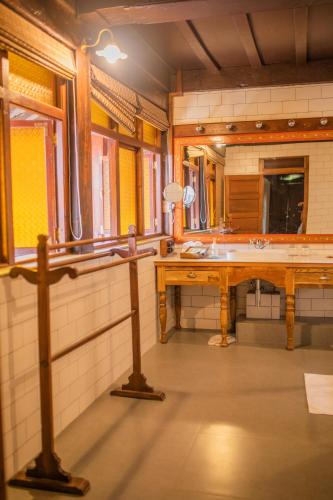 a bathroom with a sink and a large mirror at Sawantwadi Palace Boutique Art Hotel in Sawantwadi