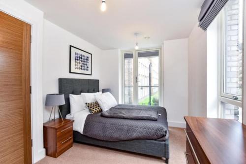 a bedroom with a bed and a table and window at Luxury 2 Bedroom 2 bathroom Apartment -Borough Market/ London Bridge in London