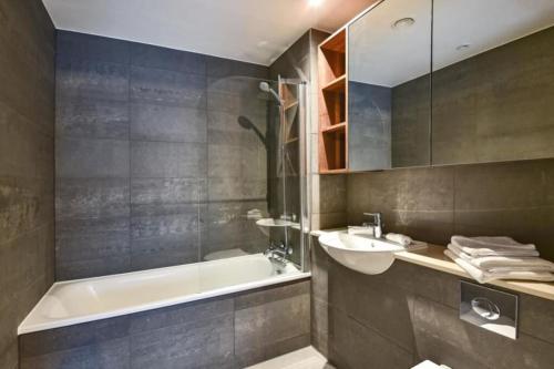 a bathroom with a bath tub and a sink at Luxury 2 Bedroom 2 bathroom Apartment -Borough Market/ London Bridge in London