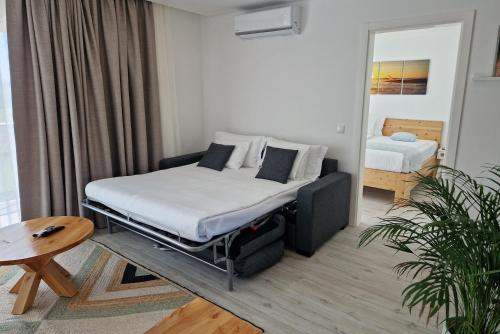 a bedroom with a bed and a couch in a room at Ericeira Surf Apartments in Ericeira