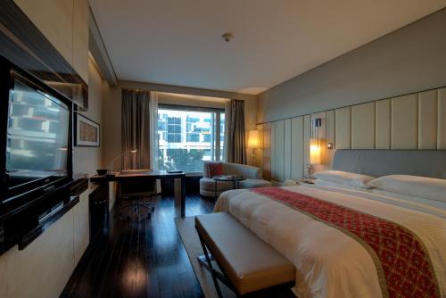 a hotel room with a large bed and a television at JW Marriott Hotel New Delhi Aerocity in New Delhi