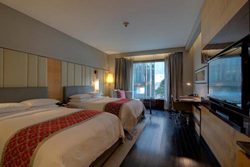 a hotel room with two beds and a flat screen tv at JW Marriott Hotel New Delhi Aerocity in New Delhi