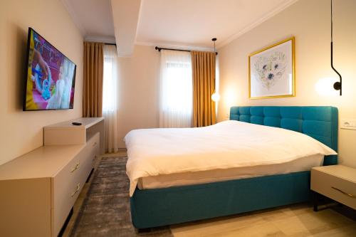 a bedroom with a blue bed and a window at First Apartments in Focşani